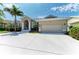 Single-story home featuring a spacious driveway, a two-car garage, and well-maintained landscaping at 5010 La Costa Island Ct, Punta Gorda, FL 33950