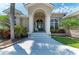 Welcoming front entrance with decorative columns, arched entryway, and lush landscaping at 5010 La Costa Island Ct, Punta Gorda, FL 33950
