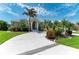Charming single-story home featuring a well-manicured lawn, mature palm trees, and a circular driveway at 5010 La Costa Island Ct, Punta Gorda, FL 33950
