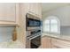 Close up of kitchen with granite countertops, tiled backsplash, and stainless steel oven and microwave appliances at 5010 La Costa Island Ct, Punta Gorda, FL 33950