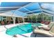 Expansive screened-in pool area with lounge chairs and a spa for ultimate relaxation at 5010 La Costa Island Ct, Punta Gorda, FL 33950