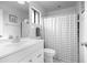 Clean bathroom featuring a new vanity, toilet, shower with checkered curtain, and decorative mirror at 5301 Linksman Pl, North Port, FL 34287