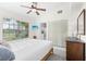 Bright bedroom featuring a ceiling fan, closet, dresser, and large window offering a view of the outside at 5301 Linksman Pl, North Port, FL 34287