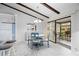 Dining room boasts wooden beams, white tile floors, with blue chairs and table, near screened-in porch at 5301 Linksman Pl, North Port, FL 34287
