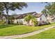 Beautiful home exterior showing lush green lawn, mature shade trees and tropical palm trees at 5301 Linksman Pl, North Port, FL 34287