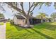 Manicured lawn with tropical tree features exterior of home with screened patio and neutral color scheme at 5301 Linksman Pl, North Port, FL 34287