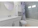 Bright bathroom features a shower-tub combo, a vanity, and a round mirror at 5527 Fairway S Dr, Punta Gorda, FL 33982