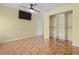 A bright bedroom with a ceiling fan, mounted television and closet at 5527 Fairway S Dr, Punta Gorda, FL 33982