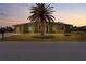 Home exterior shot showing a palm tree in the front yard at dusk at 5527 Fairway S Dr, Punta Gorda, FL 33982