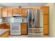 Bright kitchen featuring wood cabinets, a stainless steel refrigerator, and white appliances at 5527 Fairway S Dr, Punta Gorda, FL 33982