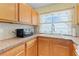 A well-equipped kitchen featuring wooden cabinets, sleek countertops, and a bright window at 5527 Fairway S Dr, Punta Gorda, FL 33982
