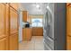 Kitchen with wooden cabinetry, stainless steel refrigerator, and bright window for natural lighting at 5527 Fairway S Dr, Punta Gorda, FL 33982