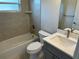 Cozy bathroom with a shower-tub combination, a modern toilet, and a sink with quartz countertops and tan tiled walls at 5970 Hornbuckle Blvd, North Port, FL 34291