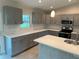 Bright kitchen featuring quartz countertops, subway tile backsplash, and stainless steel appliances and gray cabinets at 5970 Hornbuckle Blvd, North Port, FL 34291