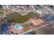 Aerial view showcasing community amenities: pool, tennis courts, and a serene pond, all within a residential area at 6336 Drucker Cir, Port Charlotte, FL 33981