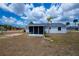 Home's backyard with a shed, screened-in lanai, and tropical palm trees in a quiet setting at 6336 Drucker Cir, Port Charlotte, FL 33981