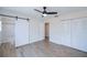 Bright bedroom with a barn door, closet space, and sleek flooring at 6336 Drucker Cir, Port Charlotte, FL 33981