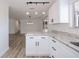 Open kitchen with granite counters, white cabinets, stainless steel appliances and modern lighting at 6336 Drucker Cir, Port Charlotte, FL 33981