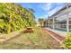 Expansive backyard featuring lush landscaping, a picnic table, and a screened pool enclosure at 6371 Mckinley Ter, Englewood, FL 34224