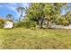 Large backyard featuring shade trees, a detached garage, and a spacious lawn at 6371 Mckinley Ter, Englewood, FL 34224