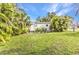 View of the backyard that features a small building, grass, and trees at 6371 Mckinley Ter, Englewood, FL 34224