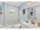 Bright bathroom features white tiled walls, tub with shower, and white vanity with a sink at 6371 Mckinley Ter, Englewood, FL 34224