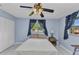 Bedroom with blue walls, a ceiling fan, and windows providing natural light at 6371 Mckinley Ter, Englewood, FL 34224