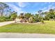 Well-manicured front yard with palm trees and tropical landscaping at 6371 Mckinley Ter, Englewood, FL 34224