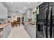 Open kitchen and dining area with white tile flooring, stainless steel appliances, and ample cabinet space at 6371 Mckinley Ter, Englewood, FL 34224