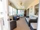 Light filled sunroom with wicker furniture, comfortable seating, ceiling fan, and direct access to the outside at 643 Blackburn Blvd, North Port, FL 34287