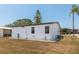 Exterior view of a white home with tidy landscaping, windows, and a clean yard at 713 Riverview Cir, North Port, FL 34287