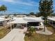 Exterior view of a home with a carport, screened-in lanai, and well-kept landscaping at 713 Riverview Cir, North Port, FL 34287