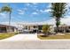 Charming single-story home with a covered carport, lush trees, and a well-manicured lawn at 713 Riverview Cir, North Port, FL 34287