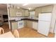 Bright kitchen features neutral cabinetry, white appliances, and laminate flooring at 713 Riverview Cir, North Port, FL 34287