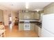 Well-lit kitchen featuring neutral cabinets, white appliances, and laminate flooring throughout at 713 Riverview Cir, North Port, FL 34287