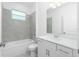 The bathroom has modern fixtures with a tiled shower over the tub and bright natural light at 8488 Saint Kitts Cir, Englewood, FL 34224