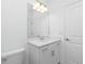 A clean bathroom features a large mirror above a white vanity and plenty of lighting at 8488 Saint Kitts Cir, Englewood, FL 34224