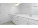 Modern bathroom featuring double vanity with white countertops and ample storage space at 8488 Saint Kitts Cir, Englewood, FL 34224