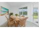 Dining room with wicker chairs, wood table, and natural light at 8488 Saint Kitts Cir, Englewood, FL 34224