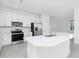 Bright kitchen featuring stainless appliances, a quartz countertop, and ample cabinet space at 8488 Saint Kitts Cir, Englewood, FL 34224