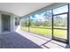 A screened-in lanai features a brick floor and a calming view of the backyard and nearby trees at 8488 Saint Kitts Cir, Englewood, FL 34224