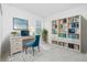 Bright office featuring a blue accent chair, desk with a laptop and a built in bookshelf at 8488 Saint Kitts Cir, Englewood, FL 34224