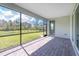 A covered patio has brick floors and beautiful screened in view to a green grass backyard at 8488 Saint Kitts Cir, Englewood, FL 34224