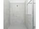 A tiled shower stall features a shower head and glass door in neutral tones at 8488 Saint Kitts Cir, Englewood, FL 34224