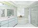 Bright bathroom with soaking tub, glass block window, and a glass enclosed shower at 910 Via Tripoli, Punta Gorda, FL 33950