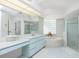 Bright bathroom with double sinks, soaking tub, glass block window, and a glass enclosed shower at 910 Via Tripoli, Punta Gorda, FL 33950