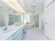 Bright bathroom with double sinks, soaking tub, glass block window, and a glass enclosed shower at 910 Via Tripoli, Punta Gorda, FL 33950