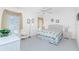 Cozy bedroom with neutral colors, floral bedding, a ceiling fan, and a large window with natural light at 910 Via Tripoli, Punta Gorda, FL 33950