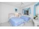 Bright bedroom with twin beds, soft blue accents, and ceiling fan at 910 Via Tripoli, Punta Gorda, FL 33950
