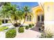 Home's entryway with a garden, stone pathway, and double doors at 910 Via Tripoli, Punta Gorda, FL 33950
